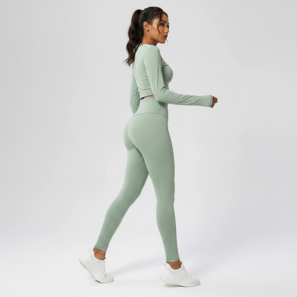 Model wearing VIVU sage green seamless high-waist leggings and matching long-sleeve top, side view.
